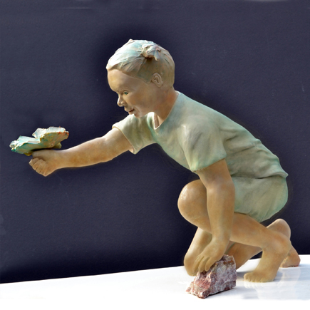 Lifelike Sculpture of child with expression of awe at the butterfly on her  hand